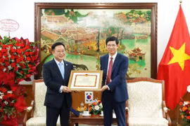 Deputy Minister of Culture, Sports and Tourism Ho An Phong presents a certificate of merit to Ly Xuong Can for his contributions to promoting tourism cooperation between the two countries. (Photo: VNA)