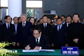 Prime Minister Pham Minh Chinh writes in the funeral book. (Photo: VNA)