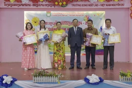 Vietnamese Ambassador to Laos Nguyen Minh Tam presents certificates of merit to the Vietnamese community in Vientiane and leaders of the Nguyen Du Lao-Vietnamese bilingual school for their contributions to preserving Vietnamese culture. (Photo: VNA)