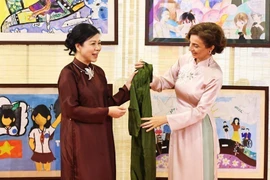 Madam Ngo Phuong Ly (L) presents a traditional Vietnamese Ao dai (long dress) to UNESCO Director-General Audrey Azoulay. (Photo: VNA)