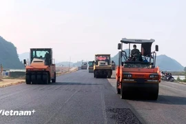 A contractor lays asphalt pavement for a section of the North-South Expressway project. (Photo: VietnamPlus)