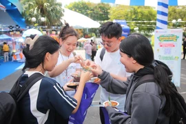 Festival-goers try local staples at Vietravel Airlines booth. (Photo: VNA)