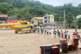 An Mi 171 helicopter of the air defence - air force service brings essential goods to flood-hit residents in Nghe An province. (Photo: VNA)