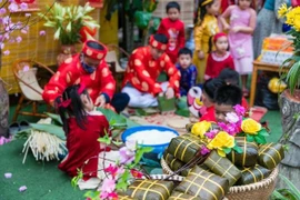 Families and neighbours are brought together in a time-honoured tradition – the making of chung or tet cakes that often lasts through the night. (Photo: VNA)