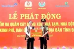 Lieutenant General Pham The Tung (R), member of the Party Central Public Security Committee and Deputy Minister of Public Security, presents the token for funding to eliminate 500 makeshift and dilapidated houses in Dak Nong province. (Photo: VNA) 