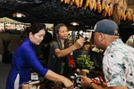 Visitors are invited to enjoy tea at the booth of Son La province. (Photo: VNA) 