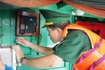 A border guard officer examines equipment on a fishing vessel. (Illustrative photo: VNA)