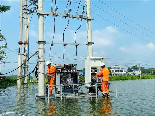 Electricity workers lift cables out of water and clean equipment to prepare for resuming power supply when water recedes at the Hoa Thach transformer station in Quoc Oai district, Hanoi. (Photo: VNA) Focal tasks, solutions specified to aid post-typhoon recovery 2.jpg