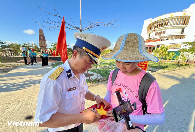 Da Tay island political commissar, Col. Le Ngoc Nam signs for a member of Working Team 11. (Photo: VietnamPlus) An Island Lighthouse full of vitality 6.webp