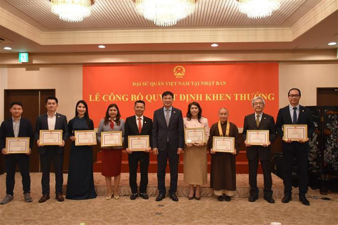Vietnamese Ambassador to Japan Pham Quang Hieu (fifth from right) presents certificates of merit to the collectives and individuals with outstanding achievements in OV affairs on June 9. (Photo: VNA) VFF official lauds solidarity of Vietnamese community in Japan 2.jpg