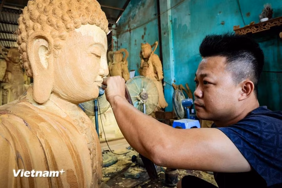 Nguyen Dang Dai, son of artisan Nguyen Dang Hac, has been involved in the craft for more than 20 years. He became familiar with the chiselling and carving sounds at a young age. (Photo: VietnamPlus)