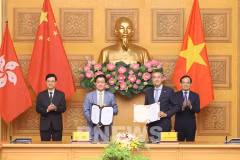 Deputy Prime Minister Tran Luu Quang (R) and Chief Executive of the Hong Kong Special Administrative Region (China) Lee Ka-chiu (L) witness the exchange of the MoU between Vietnam Airlines and the Hong Kong International Airport (HKIA). (Photo: VNA)