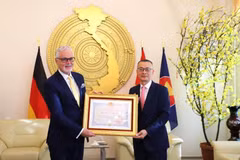Vietnamese Ambassador to Germany Vu Quang Minh (R) presents the Friendship Order to Dr. Guido Hildner, former Ambassador of Germany to Vietnam, in Berlin on October 9. (Photo: VNA)