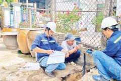 Workers from the Can Gio Clean Water Supply Company install smart water meters in Tam Thon Hiep commune, Can Gio district. (Photo: nhandan.vn) 