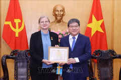 Permanent Vice President of the Ho Chi Minh National Academy of Politics Assoc. Prof. Dr Nguyen Duy Bac (R) presents the insignia to Swedish Ambassador to Vietnam Ann Måwe at a ceremony in Hanoi on June 21. (Photo: VNA)