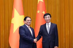 Prime Minister Pham Minh Chinh (L) and Wang Huning, a member of the Standing Committee of the Communist Party of China (CPC) Central Committee’s Political Bureau and Chairman of the Chinese People's Political Consultative Conference (CPPCC) National Committee, at their meeting in Beijing on June 26. (Photo: VNA)