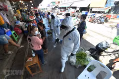 Staff spray disinfectant in a market in Samut Sakhon province, Thailand, December 21, 2020. (Photo: Xinhua/VNA)