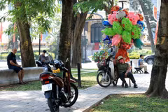 Street vendors in Hanoi make use of any shade to take a rest. (Photo: VNA)