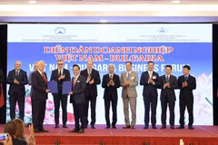 Bulgarian President Rumen Radev (sixth from the right) and other delegates witness representatives of Vietnamese and Bulgarian businesses exchanging cooperation agreements at the forum. (Photo: VNA)