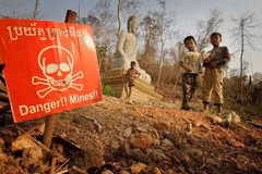 Children play near a landmine warning sign in the border area between Cambodia and Thailand. (Photo: AP)