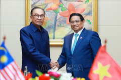 Prime Minister Pham Minh Chinh (R) and his Malaysian counterpart Anwar Ibrahim at their meeting in Vientiane on October 10. (Photo: VNA)