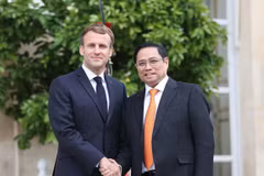 PM Pham Minh Chinh (R) and French President Emmanuel Macron in the Vietnamese leader's visit to France in 2021. (Photo: VNA)
