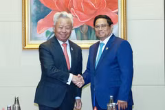 Prime Minister Pham Minh Chinh (right) receives President of the Asian Infrastructure Investment Bank (AIIB) Jin Liqun in Vientiane on October 10. (Photo: VNA)
