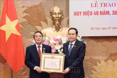 NA Chairman Tran Thanh Man (right) presents the 40-year Party membership badge to Nguyen Duc Hai, member of the Party Central Committee and Vice Chairman of the legislature, on June 7. (Photo: VNA)