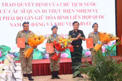 Deputy Defence Minister Senior Lieutenant General Hoang Xuan Chien (second, right) presents the State President's decisions to the three officers on October 7. (Photo: VNA)
