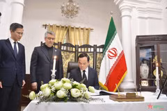 Deputy PM Tran Luu Quang writes in the condolence book at the Iranian Embassy in Hanoi on May 23. (Photo: qdnd.vn)