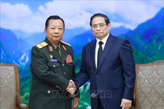 PM Pham Minh Chinh (right) receives General Chansamone Chanyalath, Deputy PM and Minister of National Defence of Laos, in Hanoi on July 25. (Photo: VNA)