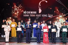 Party General Secretary To Lam (third from left, front row) and Politburo member, Secretary of the Party Central Committee and Chairman of the Party Central Committee's Commission for Information and Education Nguyen Trong Nghia (fourth from right, front row) present Certificates and Emblems to honour 25 typically outstanding models nationwide in studying and following President Ho Chi Minh's thought, morality and style. (Photo: VNA)