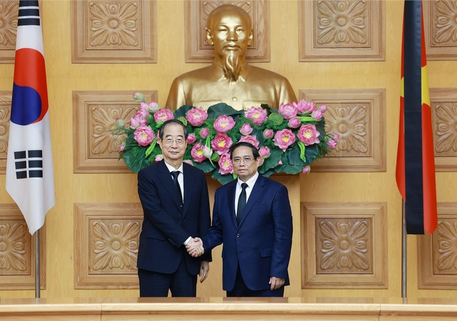 Prime Minister Pham Minh Chinh (R) hosts a reception for his Korean counterpart Han Duck Soo. (Photo: VNA) PM.jpg