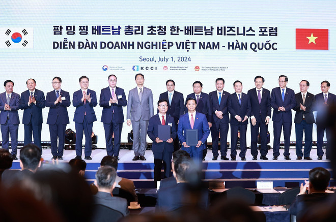 Prime Minister Pham Minh Chinh witnesses the exchanges of cooperation agreements between businesses of the two countries. (Photo: VNA) hoptac.jpg