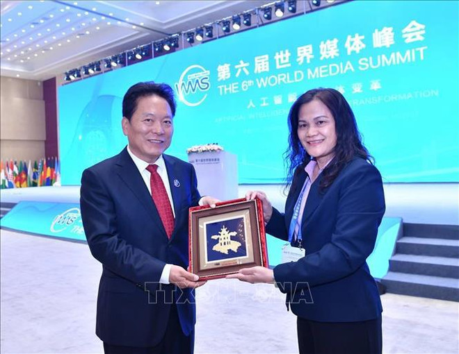 VNA Deputy General Director Nguyen Thi Su gives a present to Vice President of Xinhua News Agency Yuan Bingzhong. (Photo: VNA) hình_ảnh (4).jpg