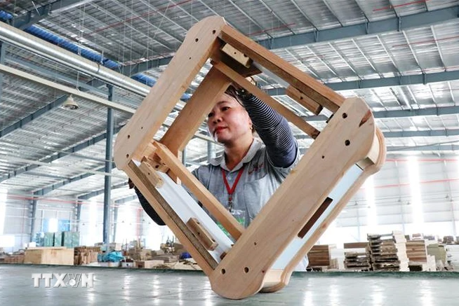 A worker check a product for export at a wood factory in the southern province of Binh Duong. (Photo: VNA) go.PNG