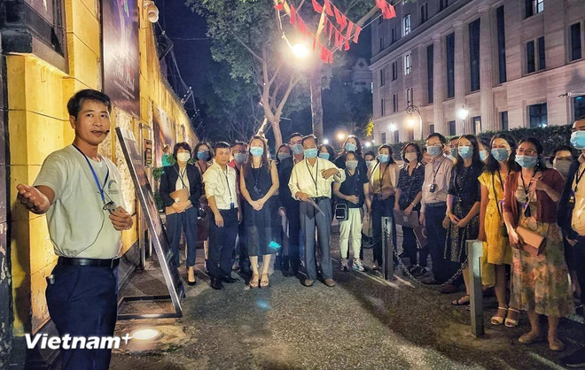 Tourists listen to an introduction before starting the Hoa Lo night tour (Photo: VietnamPlus) nha tu hoa lo.webp
