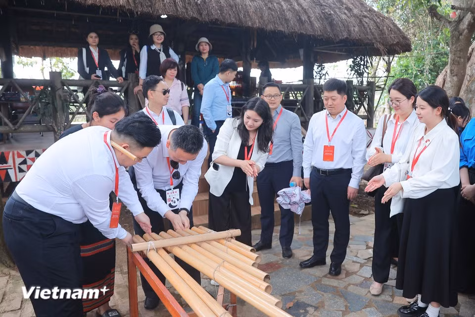 The player places their hands close to the ends of the bamboo tubes and claps, causing air pressure to vibrate the column of air inside the tubes, producing sounds. (Photo: VietnamPlus)