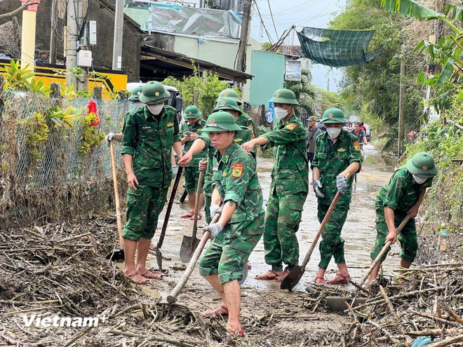 Border guards clean roads and houses after the floods (Photo: VietnamPlus)