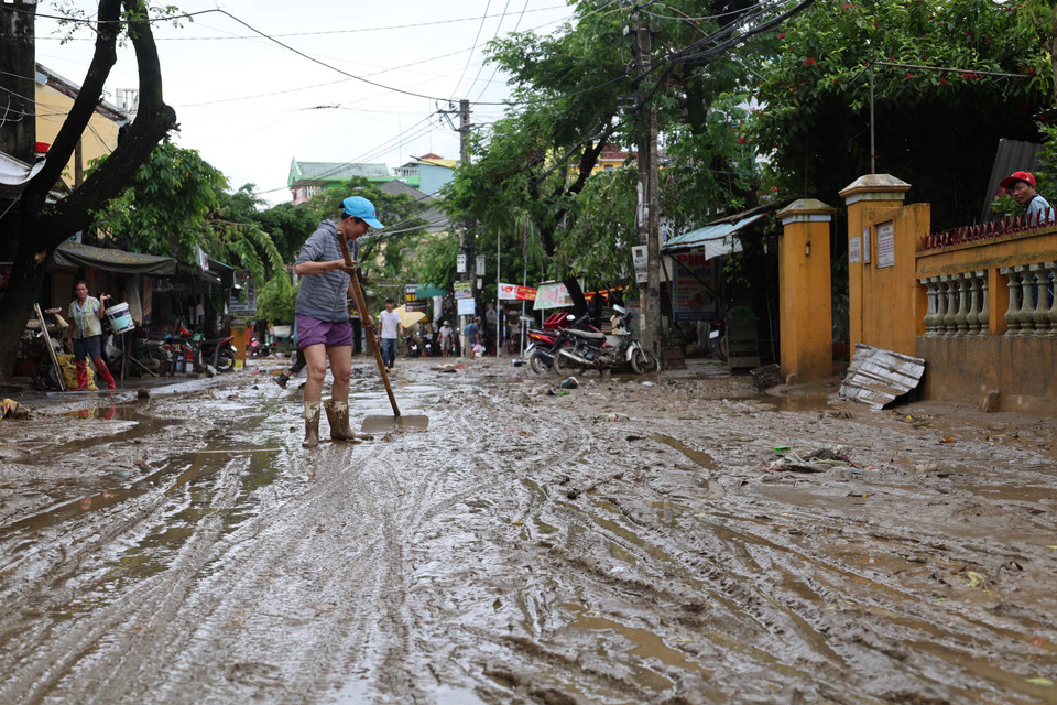 Residents remove mud along Nguyen Tri Phuong street. (Photo: VNA)