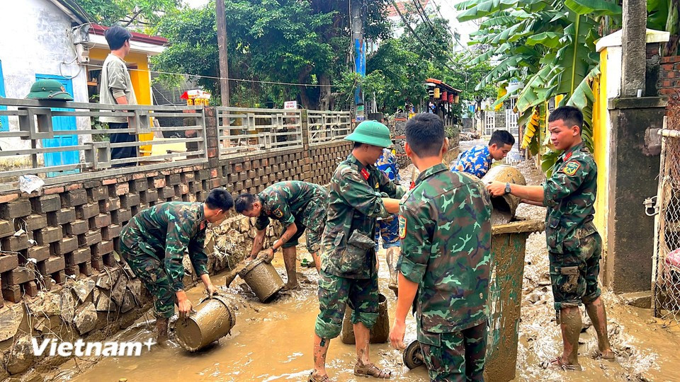 Soldiers have to clear mud from major streets to narrow alleys. (Photo: VietnamPlus)
