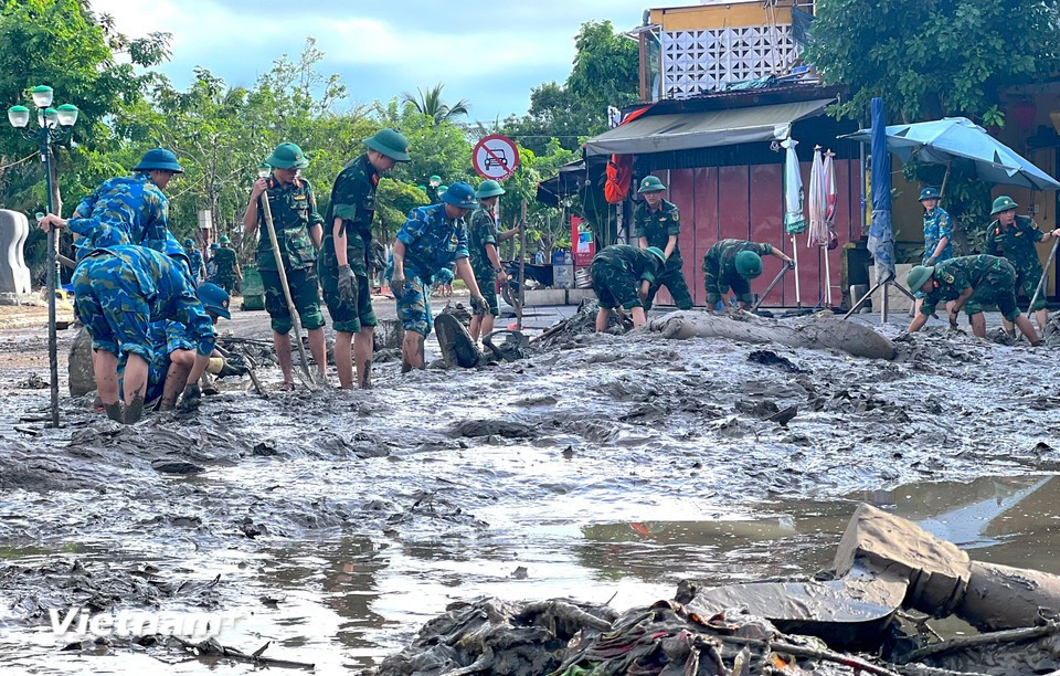 From early morning, hundreds of officers and soldiers are mobilised by the army to clear mud in the ancient streets of Hoi An, Da Nang city. (Photo: VietnamPlus)
