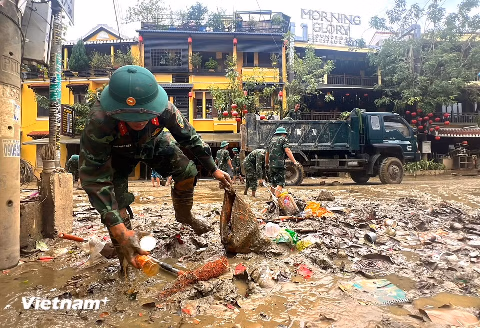 With large amounts of waste trapped in the mud, officers and soldiers have to wade through it to sort and remove rubbish for separate disposal. (Photo: VietnamPlus)