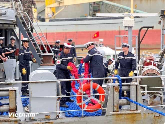Sailors work with port staff to prepare heavy mooring ropes for berthing (Photo: VietnamPlus)