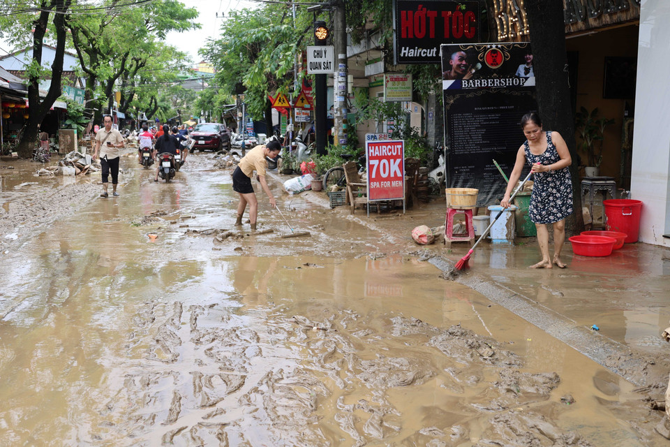 Residents remove mud along Nguyen Tri Phuong street (Photo: VNA)