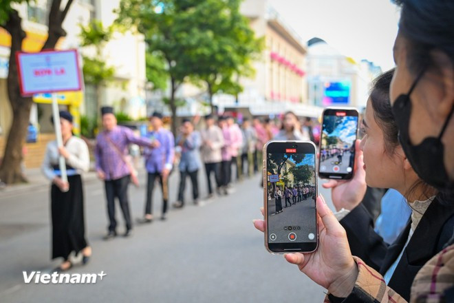 Thousands of Hanoians stop along the streets to watch the impressive cultural performances (Photo: VietnamPlus)