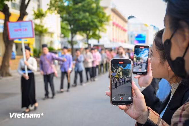 Thousands of Hanoians stop along the streets to watch the impressive cultural performances (Photo: VietnamPlus)