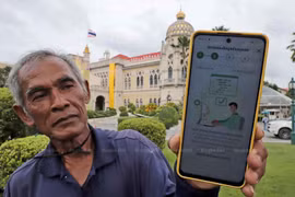 A Thai gardener shows a message on his phone in response to his registration for the digital wallet scheme. (bangkokpost.com)