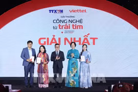 VNA General Director Vu Viet Trang (second, right) and Chairman of the Vietnam Journalists Association Le Quoc Minh (centre) hand over prizes to the winners at the ceremony. (Photo: VNA)