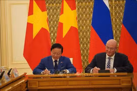 Deputy Prime Minister Tran Hong Ha (L) and his Russian counterpart Dmitry Chernyshenko sign the meeting's minute (Photo: VNA)